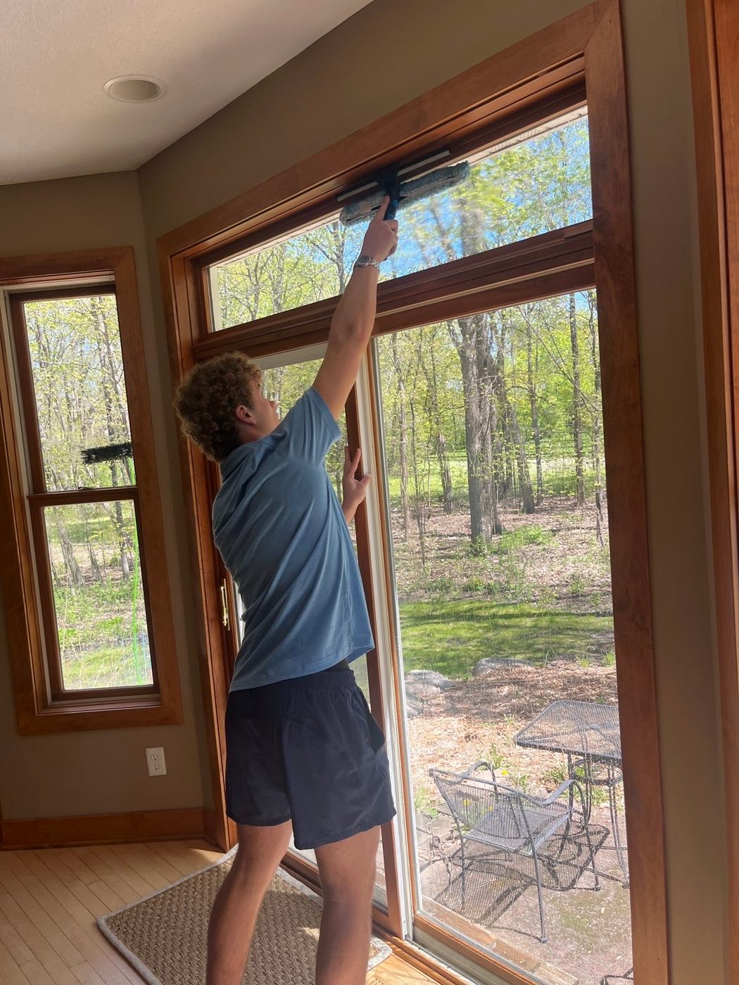 Technician cleaning a large interior window with professional equipment