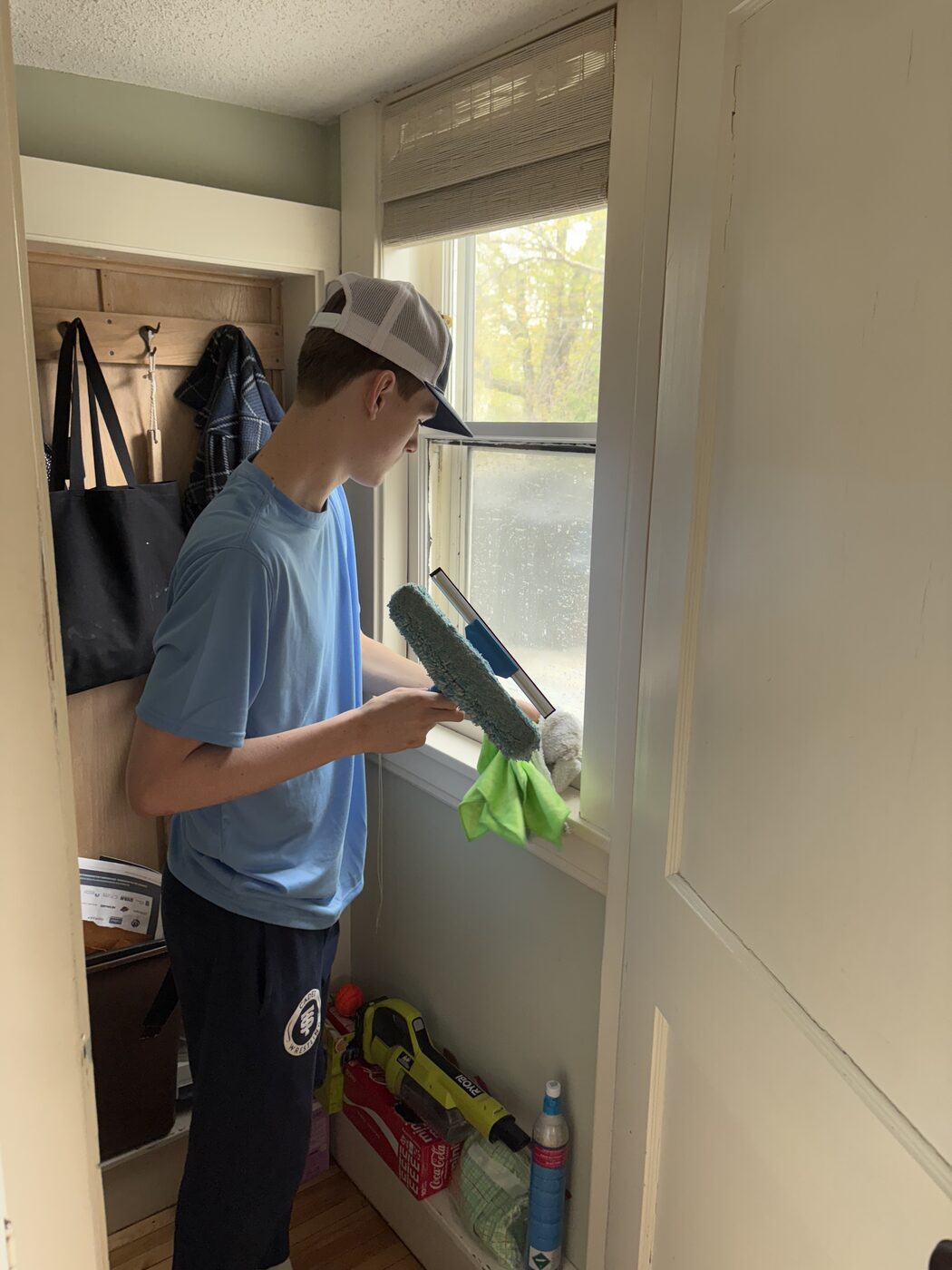 Technician squeegeeing an interior window clean inside a Twin Cities home