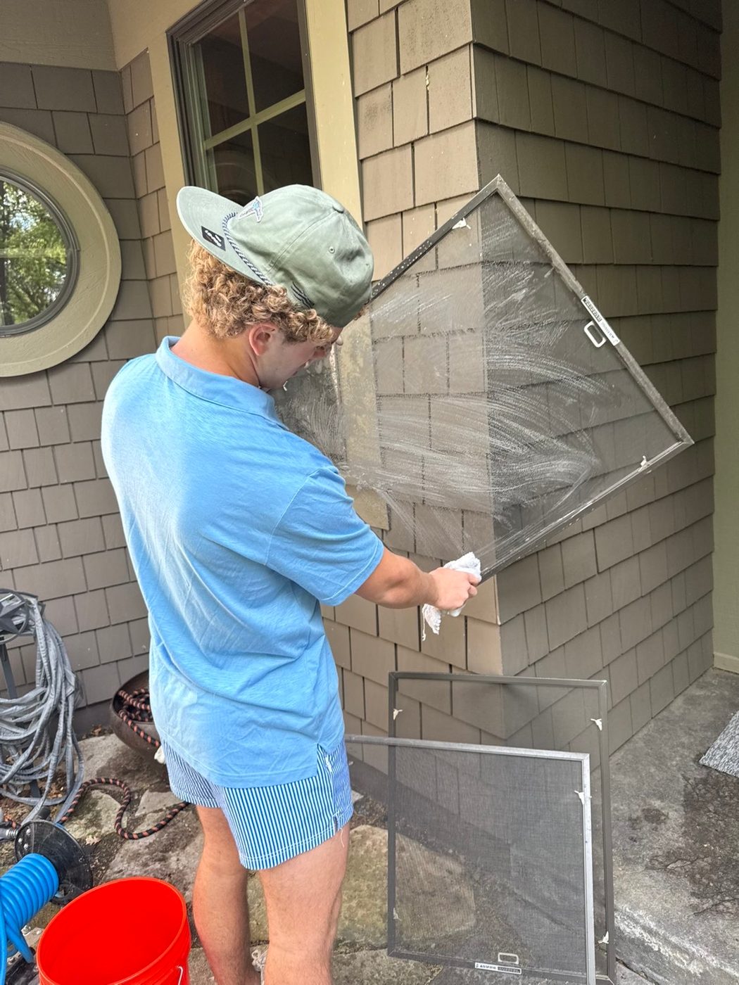 Technician removing and hand-cleaning a window screen