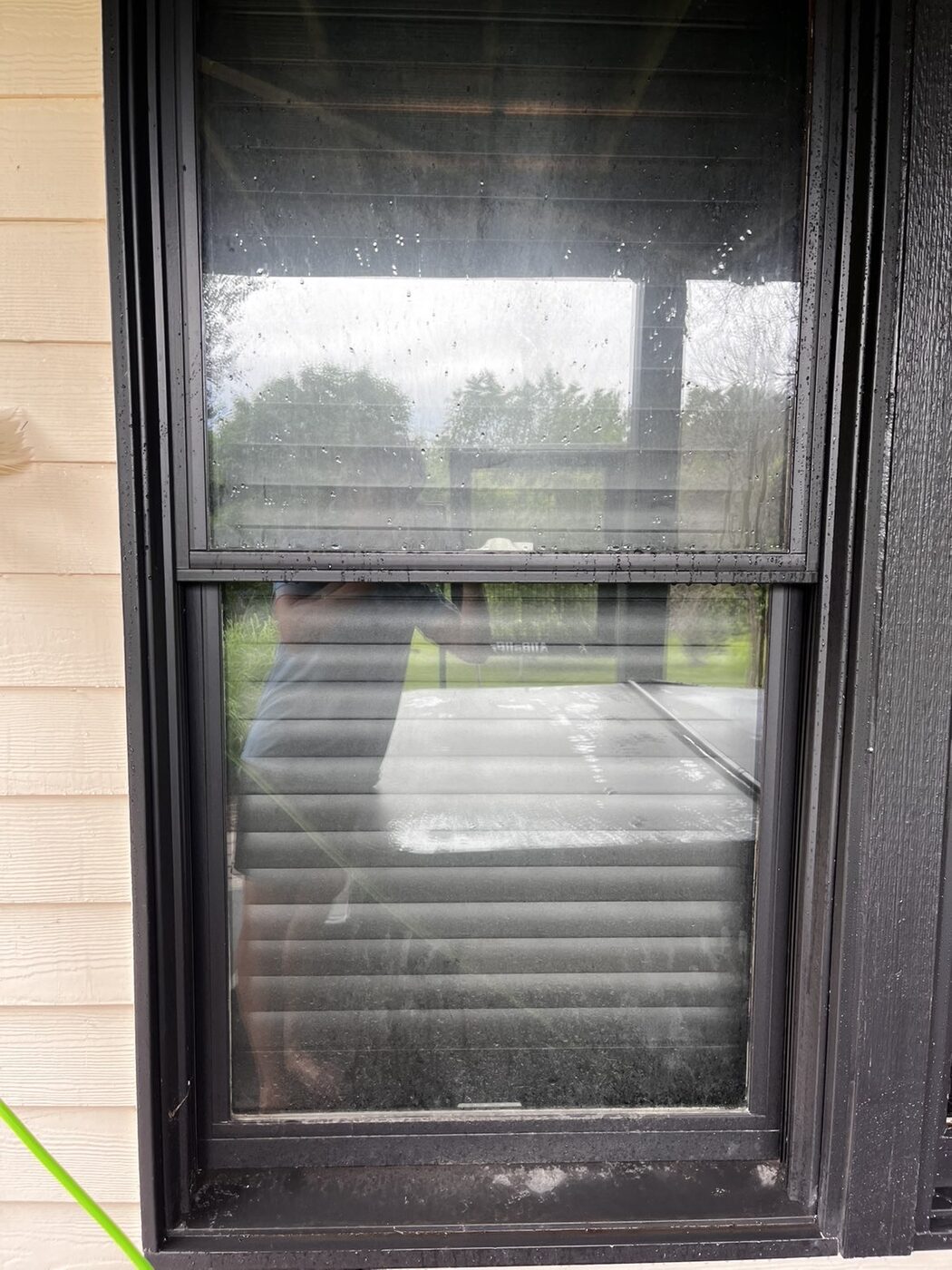 Exterior window covered in water spots, dust, and grime before cleaning